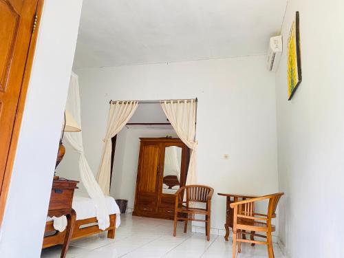 a room with a bed and a table and chairs at suris bungalow 2 in Pabean Buleleng