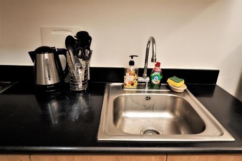 a kitchen counter with a sink in a kitchen at MOA Pasay 1156 Shore Residences Hotel Vibe Staycation in Manila