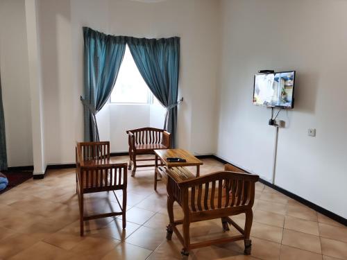 - un salon avec des chaises, une table et une télévision dans l'établissement Tiara Beach Resort Cozy Studio Apartment, à Port Dickson