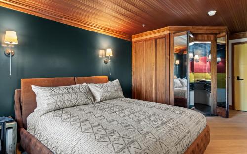 a bedroom with a large bed with a wooden ceiling at Wolfe's Hotel Moab in Moab