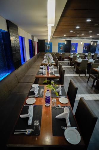 a long dining room with long tables and chairs at Hotel Olive Eva in Kakkanad