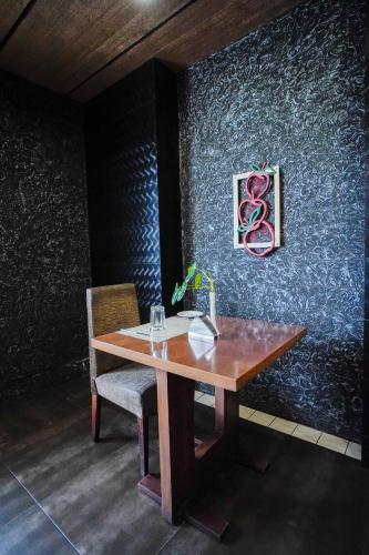 a wooden table with a chair and a painting on a wall at Hotel Olive Eva in Kakkanad