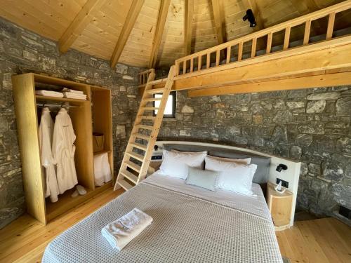 ein Schlafzimmer mit einem Bett in einer Steinmauer in der Unterkunft Windmills Village Amarynthos in Amarinthos