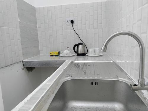 a sink in a kitchen with a faucet at Nyota Apartment in Nungwi