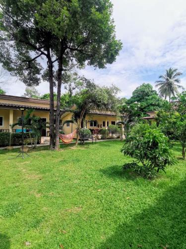 a yard with a hammock in front of a house at SER-EN-DIP-I-TY - SHA Extra Plus in Ko Lanta