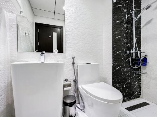 a white bathroom with a toilet and a shower at Perfect Studio in Arjan in Dubai