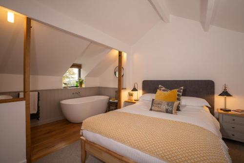 a bedroom with a large bed and a bath tub at Beautiful Luxury one bedroom retreat in Far Sawrey in Far Sawrey