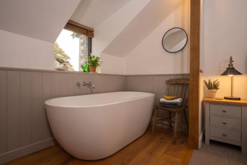 a bathroom with a large white tub in a attic at Beautiful Luxury one bedroom retreat in Far Sawrey in Far Sawrey