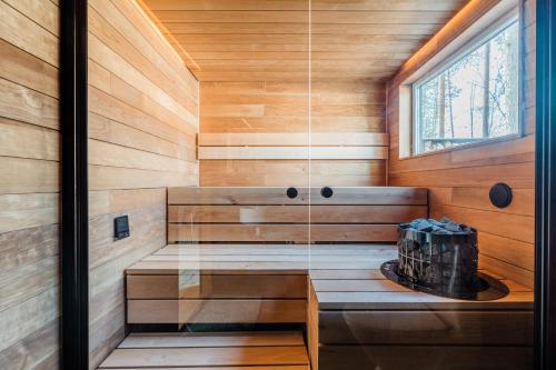 una sauna con paredes de madera y una ventana en Ternu Minivilla en Rovaniemi