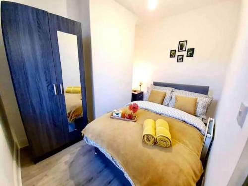 um quarto com uma cama grande e almofadas amarelas em Modest Urban Escape em Liverpool