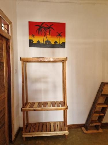 a wooden shelf in a room with a painting on the wall at Coconut Mafia Island Bungalows in Utende