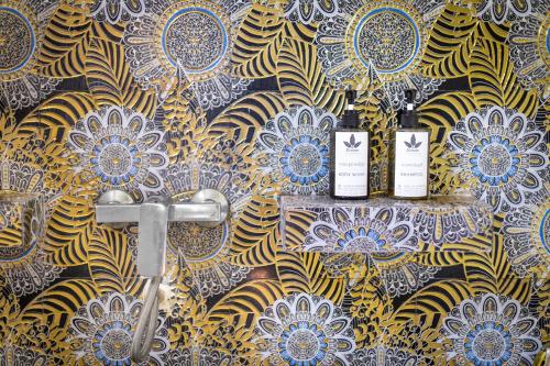 Phumĭ Réach Born (2)的住宿－Banana Resort, le petit nid de Caro，浴室的墙上装有两瓶葡萄酒