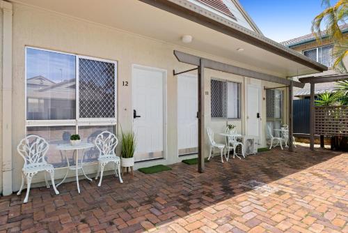 a patio with a table and chairs on a brick patio at Central Motel Mooloolaba and Apartments in Mooloolaba