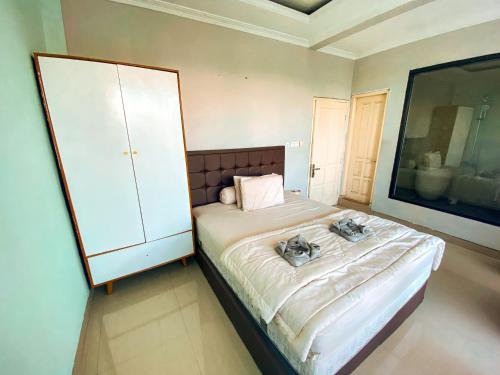 a bedroom with a large bed and a white cabinet at Villa Kamar Tamu Warungboto in Timuran