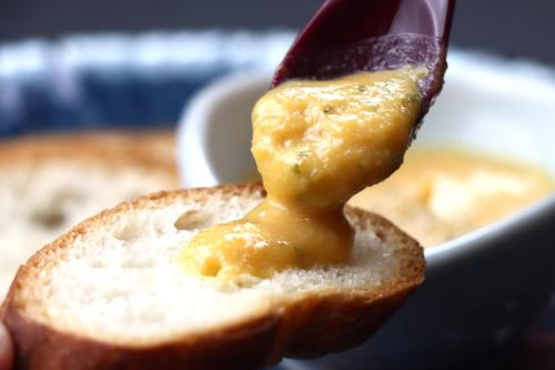a person is holding a piece of bread with cheese on it at Baigetsu Ryokan in Shimo-suwa