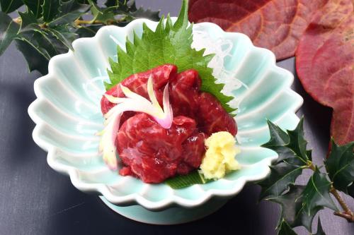 Un plato blanco con un trozo de comida. en Baigetsu Ryokan, en Shimo-suwa