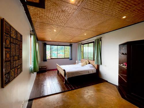 een slaapkamer met een bed en twee ramen. bij 泰暖WarmThai（karon） in Karon Beach