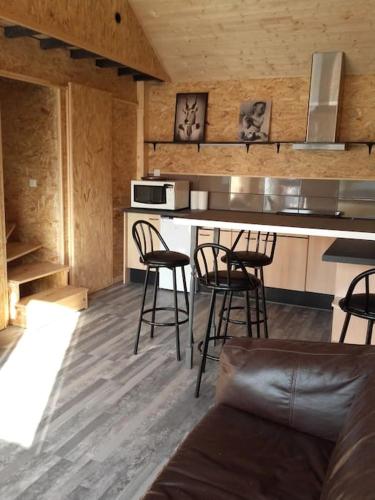 a kitchen with bar stools and a counter top at Cabane perchée in Saint-Brieuc