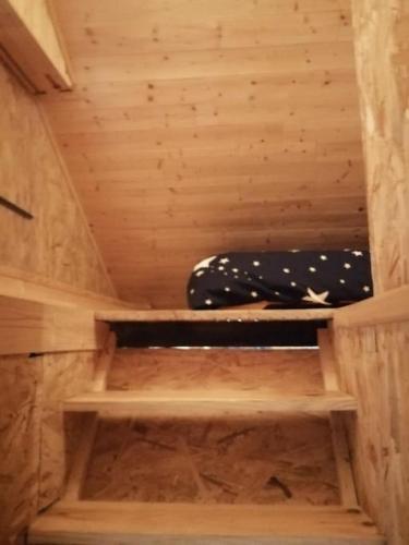 a small wooden sauna with a bed in it at Cabane perchée in Saint-Brieuc