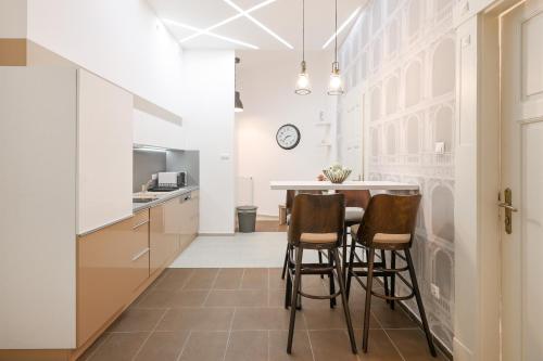 ブダペストにあるDeluxe Central Apartment with 4BEDRM 2 BATHRMのキッチン(テーブル、椅子付)