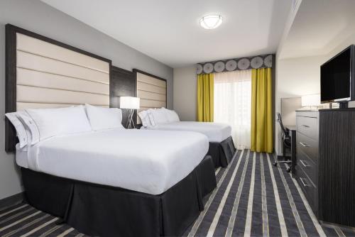 ein Hotelzimmer mit 2 Betten und einem Flachbild-TV in der Unterkunft Holiday Inn Express and Suites Norman, an IHG Hotel in Norman