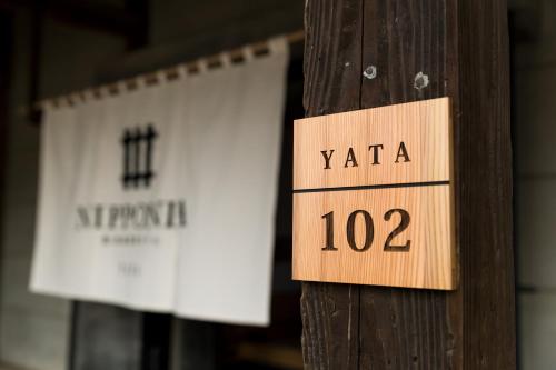 a wooden sign that says yaza on a wooden pole at NIPPONIA Sawara Merchant Town Hotel in Katori