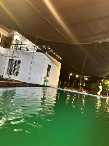 a swimming pool at night with a person walking by a house at Chateau d' sentier in Davao City