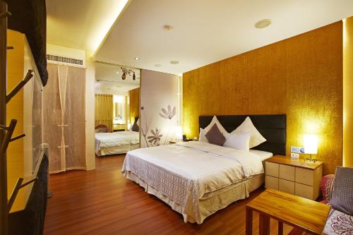 薇風情汽車旅館 - 台南館 في Liujia: غرفة فندقية بسرير كبير واريكة