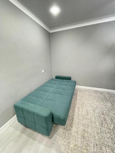 a room with a blue couch in a room at # 67 Привлекательная и просторная студия in Atyraū