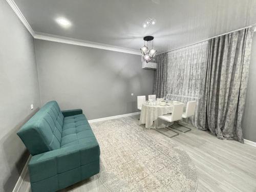 a living room with a blue couch and a table at # 67 Привлекательная и просторная студия in Atyraū