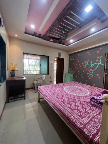 1 dormitorio con 1 cama con colcha púrpura en Patil Homestay, en Alībāg