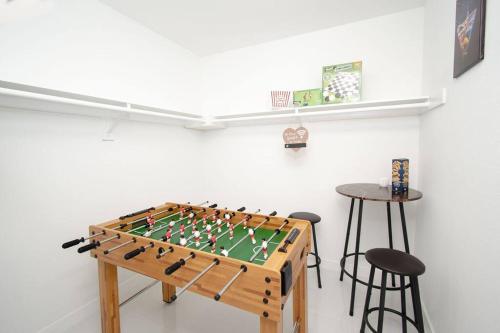 a foosball table in a room with two stools at STAR HOME-wynwood/airport/miami in Miami