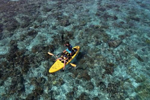 dos personas en un kayak amarillo en el agua en homestay noah, en Likupang