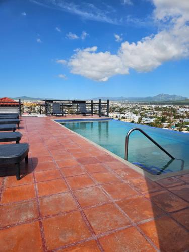 a swimming pool on the roof of a building at Elegant Condo in an Upscale Building in Cabo San Lucas