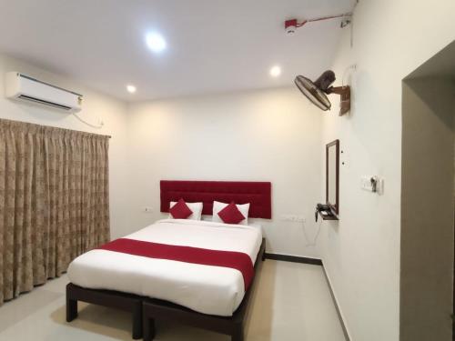 a bedroom with a bed with red pillows at HOTEL TAWFEEQ PALACE in Thanjāvūr