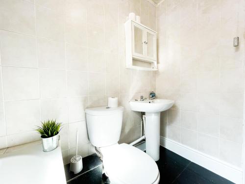 a white bathroom with a toilet and a sink at Chic City Loft Room in Liverpool