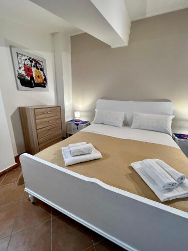 a bedroom with a large bed with two towels on it at Sicilia Bedda Apartment in Messina