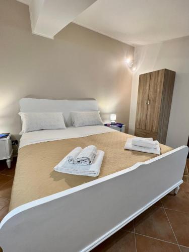 a bedroom with a large bed with towels on it at Sicilia Bedda Apartment in Messina