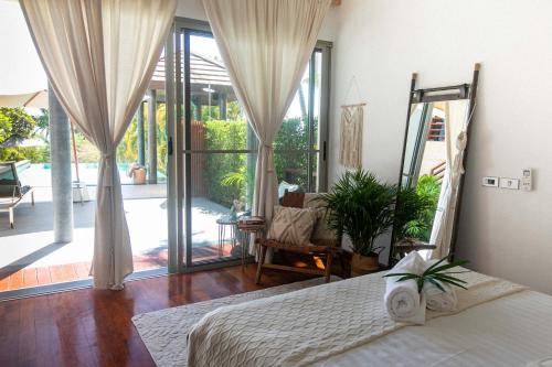 um quarto com uma cama e uma grande janela em Luxury 3-Bedroom Villa with Seaview, Pool, Cinema, and Gym! em Nathon Bay