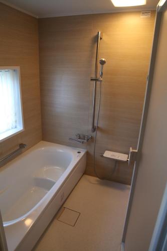een badkamer met een bad, een douche en een wastafel bij 西神楽の杜 in Nishi-kagura