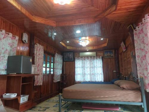 a bedroom with a bed in a wooden room at Duangmanee home stay 