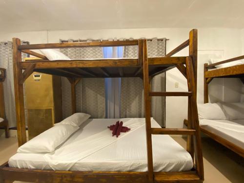 two bunk beds with a cross on the bottom bunk at Aquaholik Traveler's Lodge in El Nido