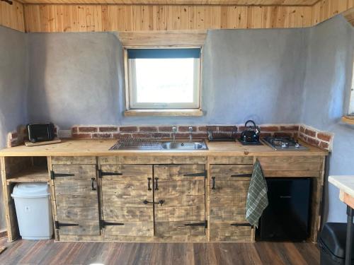 a kitchen with a counter with a sink and a window at Honeysuckle Straw Bale Cabin in Dallas