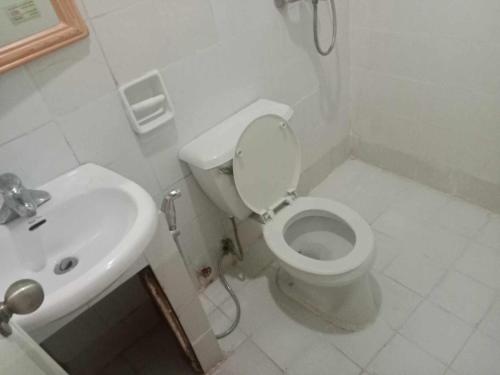 a white bathroom with a toilet and a sink at WJV INN CABANCALAN in Mandaue City