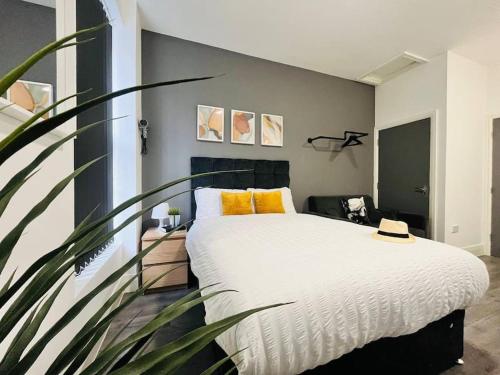 a bedroom with a large white bed with yellow pillows at Urban and stylish Central Studio Apartment in Liverpool with high speed free wifi in Liverpool