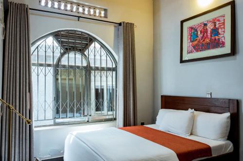 a hotel room with a bed and a window at Nyumbani Cottages Kicukiro in Kigali