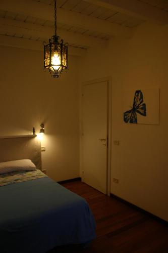 a bedroom with a bed and a chandelier at Dragonfly B&B in Certosa di Pavia