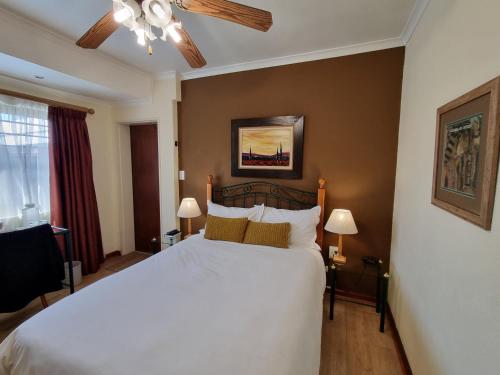 ein Schlafzimmer mit einem großen weißen Bett in einem Zimmer in der Unterkunft Old Oak Guest House in Bellville