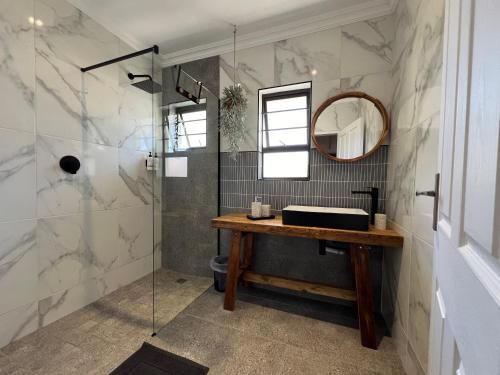 a bathroom with a sink and a mirror at Coral Tree Boutique Guesthouse in East London