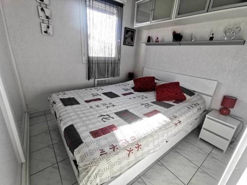 - une chambre avec un lit doté d'oreillers rouges dans l'établissement 039 Marina Bay 403, au Cap d'Agde
